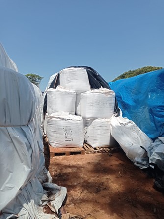 Big Bags de fertilizantes empilhados em três camadas, sobre paletes e armazenado em lonas. 