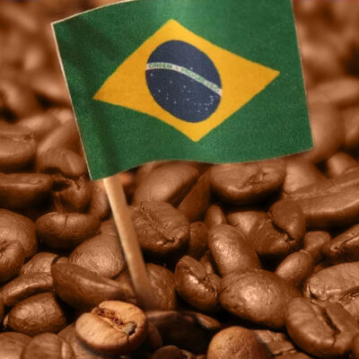 graos-de-cafe-em-close-com-bandeira-do-Brasil-colocada-em-meio-a-eles